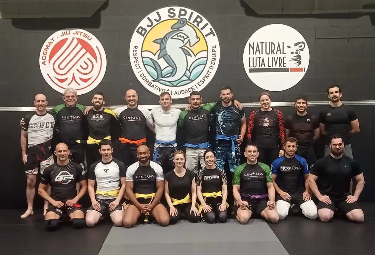 Photo de groupe devant le mur aux logos du club.